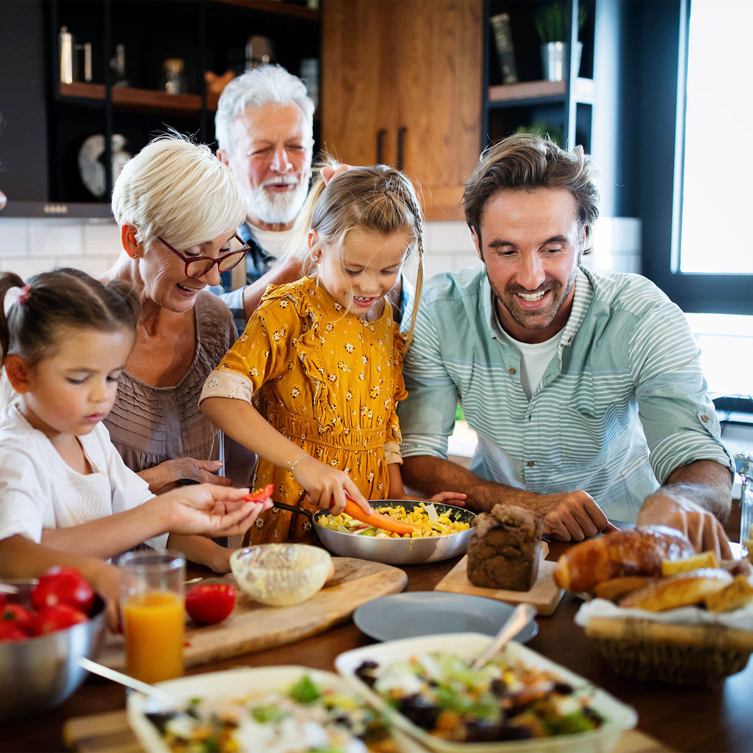 Cheerful happy family spending good time together while cooking in kitchen